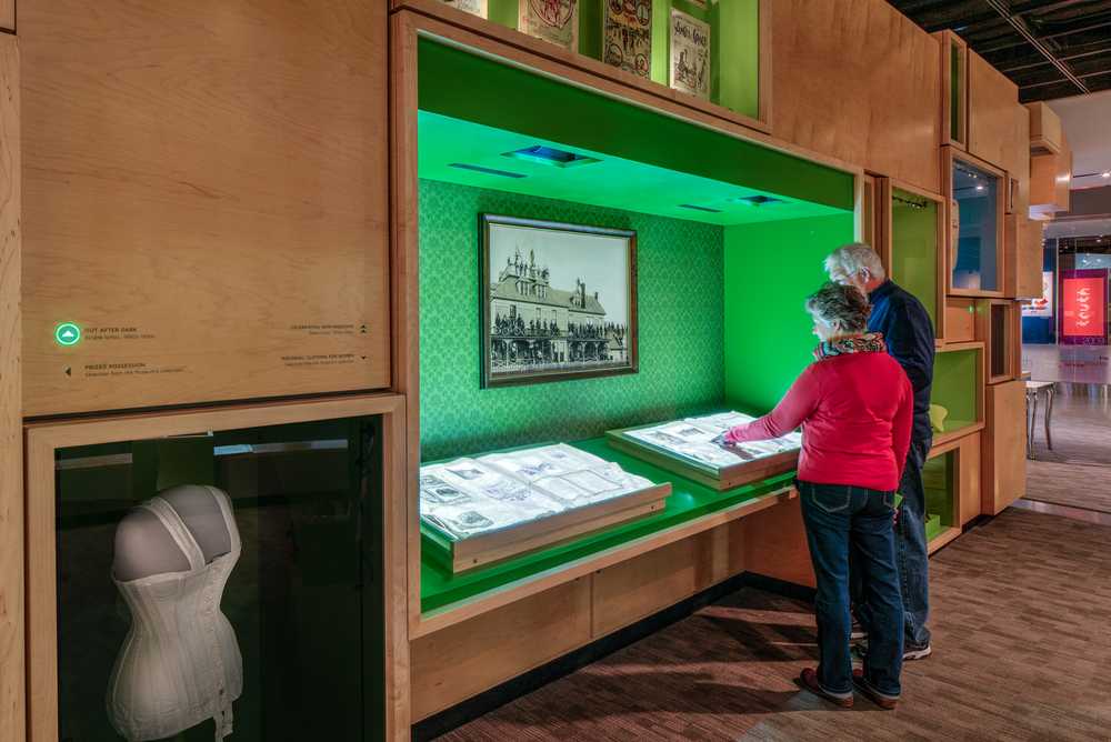Two people interacting with a large book featuring animated projections.
